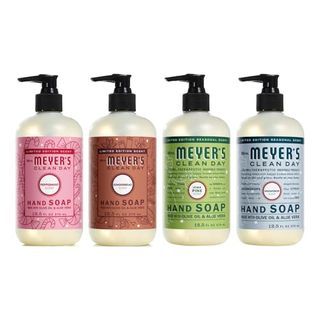 Four plastic pump bottles of hand soap with different labels. One pink, one brown, one green, and one blur. 