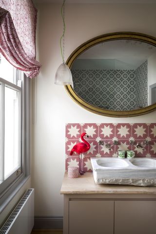 white bathroom with red patterned splashback tiles, red floral blind