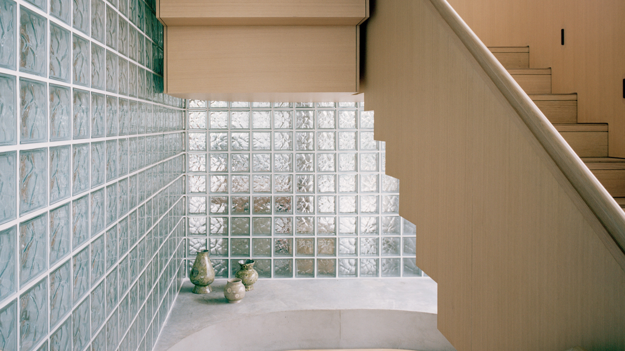 Two full glass block walls with light oak double staircase 