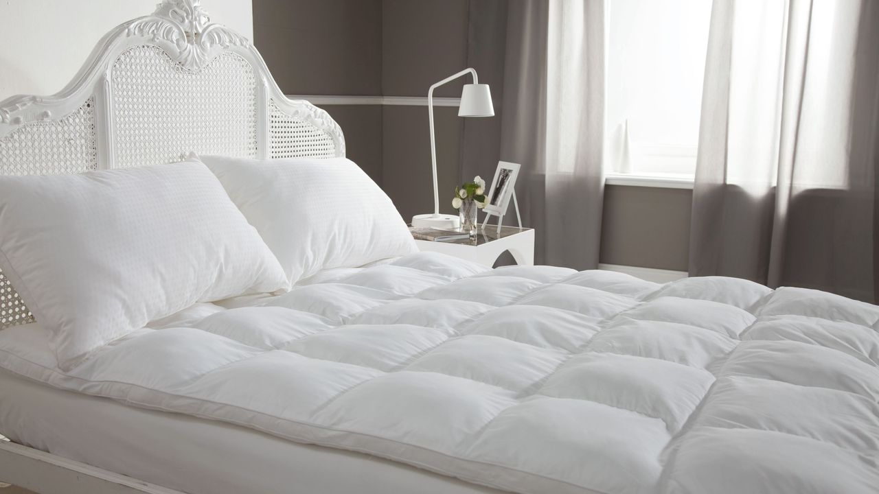 Quilted plump mattress topper on bed