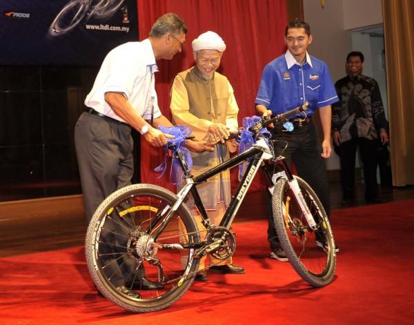 Le Tour de Langkawi 2010 director Dato' Mohd Yasin Mohd Saleh (left) presents a bicycle to Tuan Guru Dato' H Nik Abdul Azis