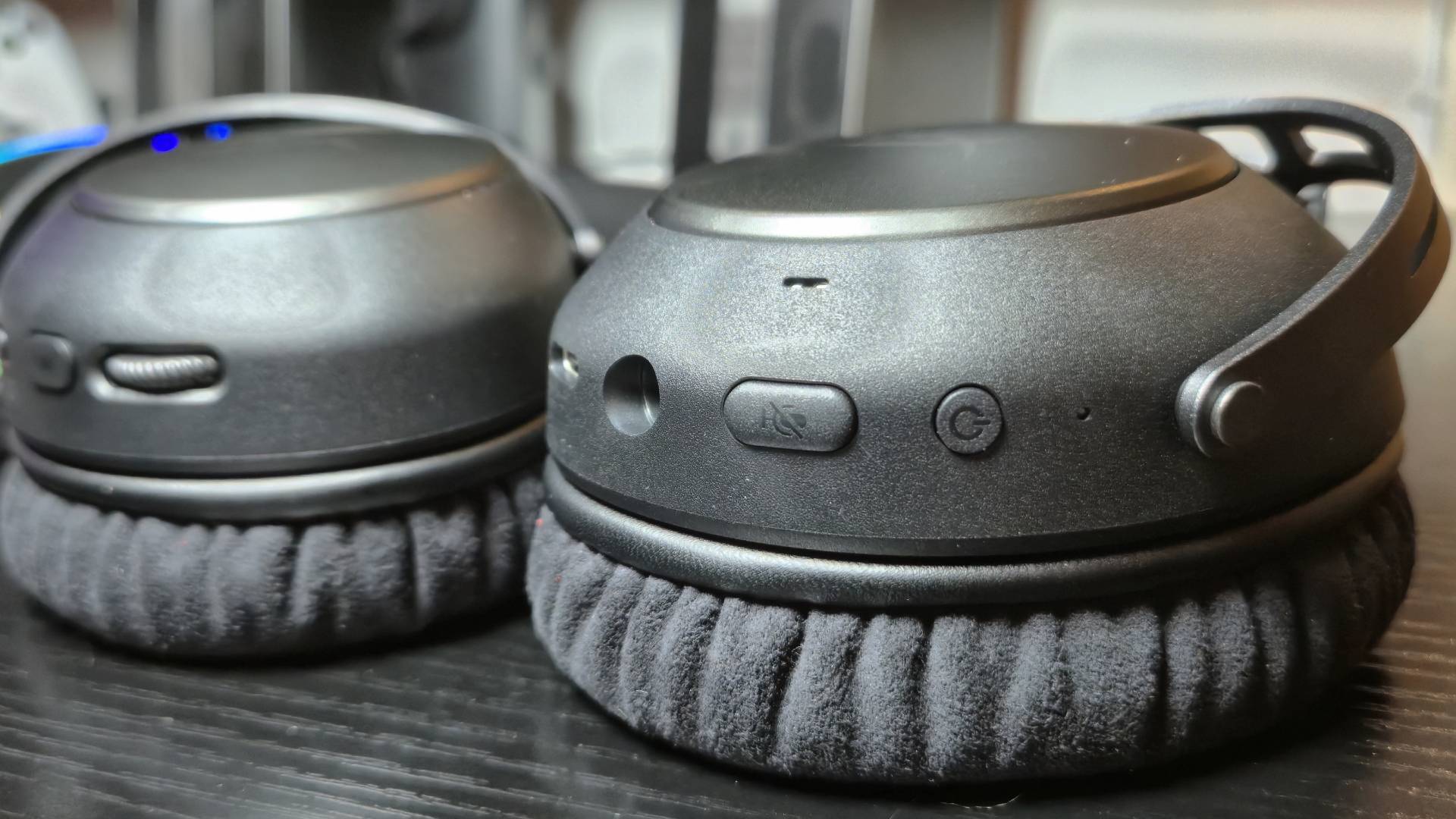 Photo of the buttons on the side of a headset that&#039;s sitting on a black gaming desk.