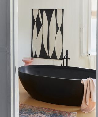 Black bathroom decor with bathtub and monochrome wall art