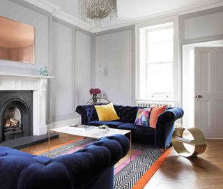 Light grey living room with multicolor rug and blue sofa