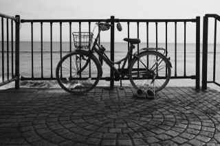 Bike parked up against a railing next to some shoes in black and white