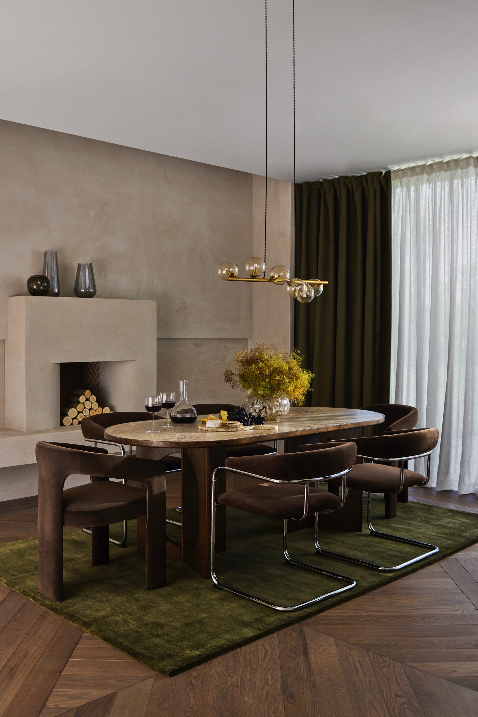 a dining room with limewash walls, velvet chairs and a stone topped table