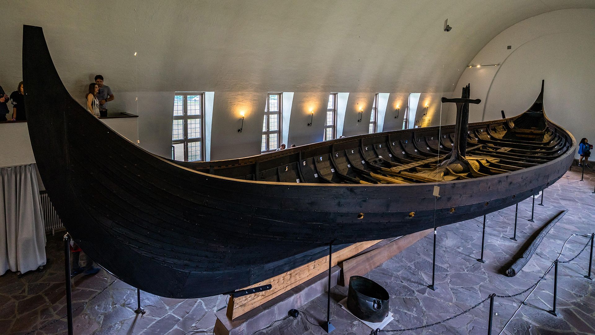 A Viking ship sits on display in a museum.