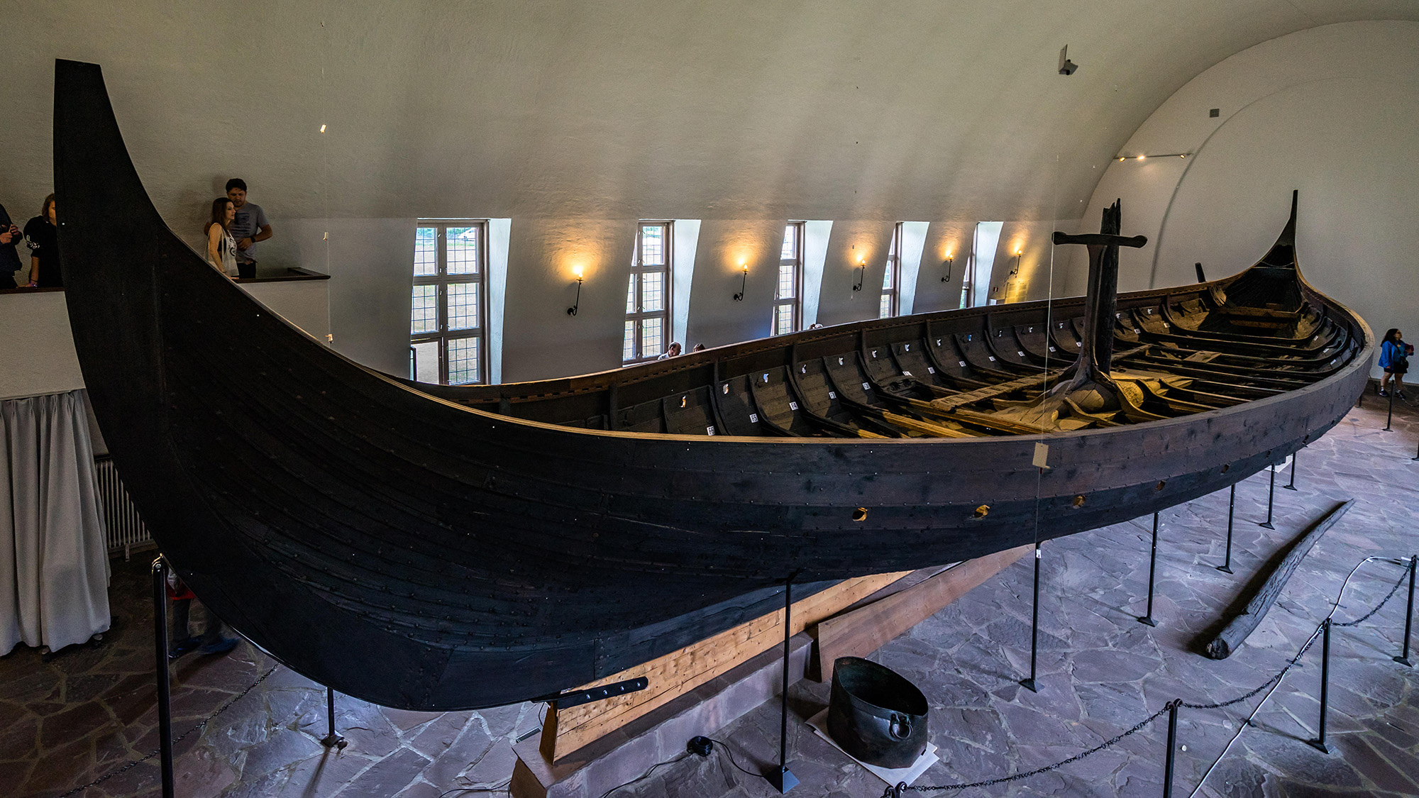A Viking ship sits on display in a museum.