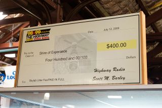 The oversized check by the Nevada & California-based radio station The Highway, used to finally pay a $400 litter fine after 30 years, is on display above the case.