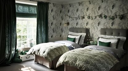A green bedroom with two single beds and green curtains