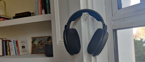 The Sennheiser HD-660S2 over-ear headphones hanging on a hook near a window