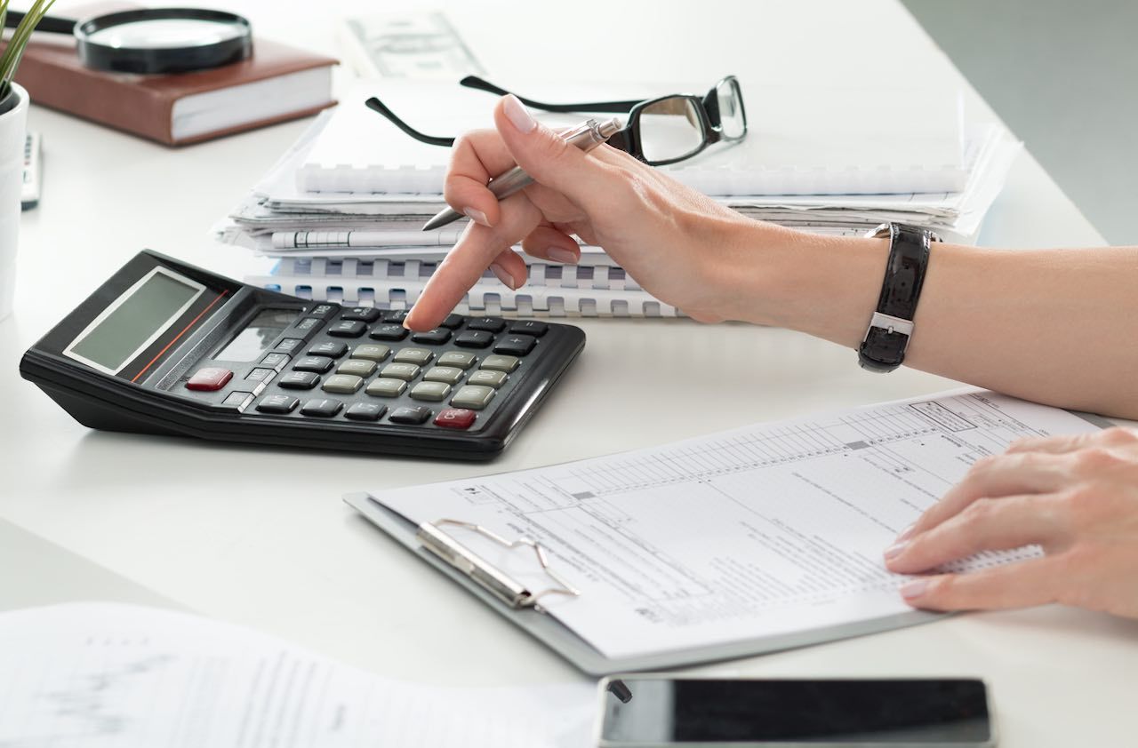 Close up of female accountant or banker making calculations. Savings, finances and economy concept