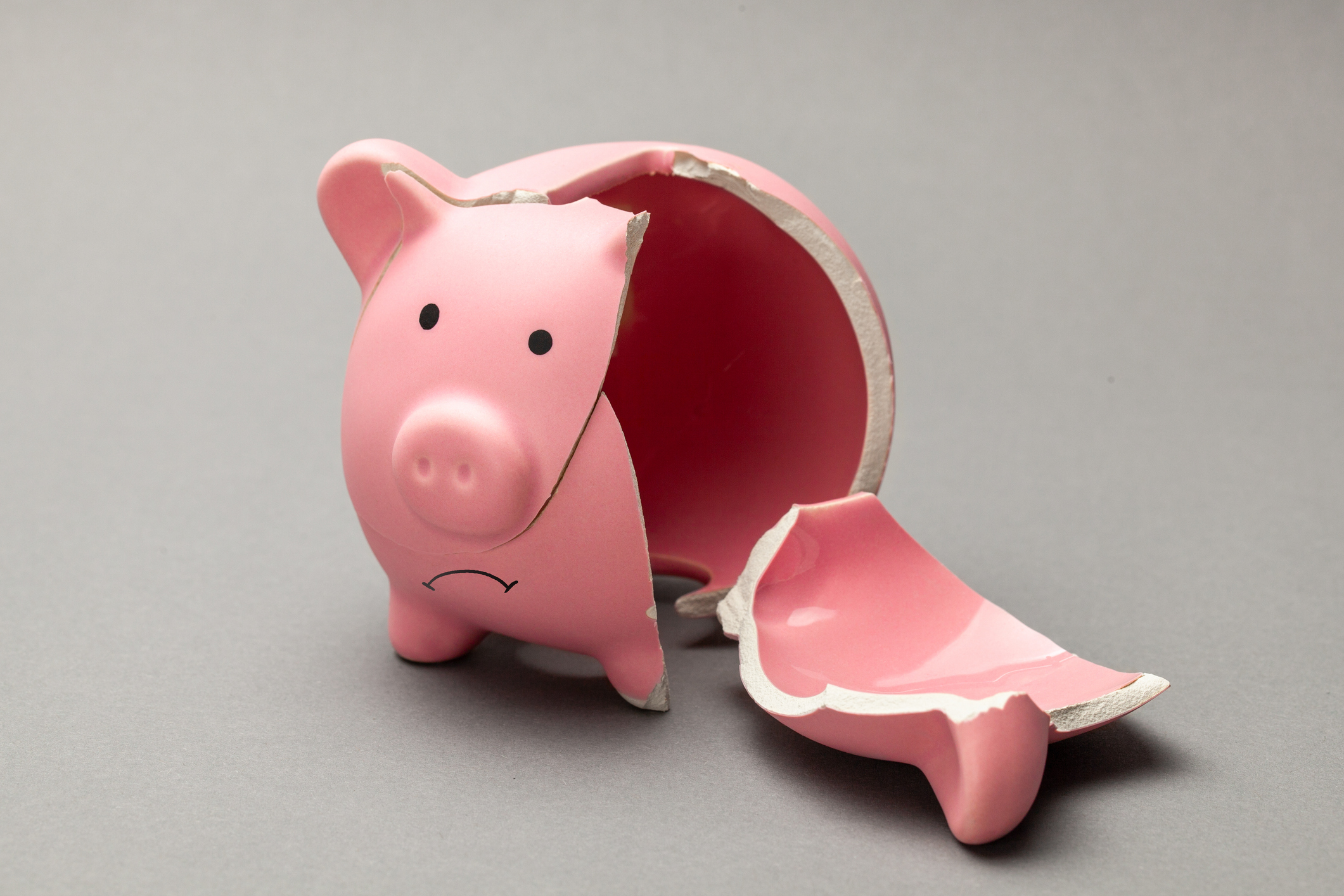 Broken piggy bank on gray background.
