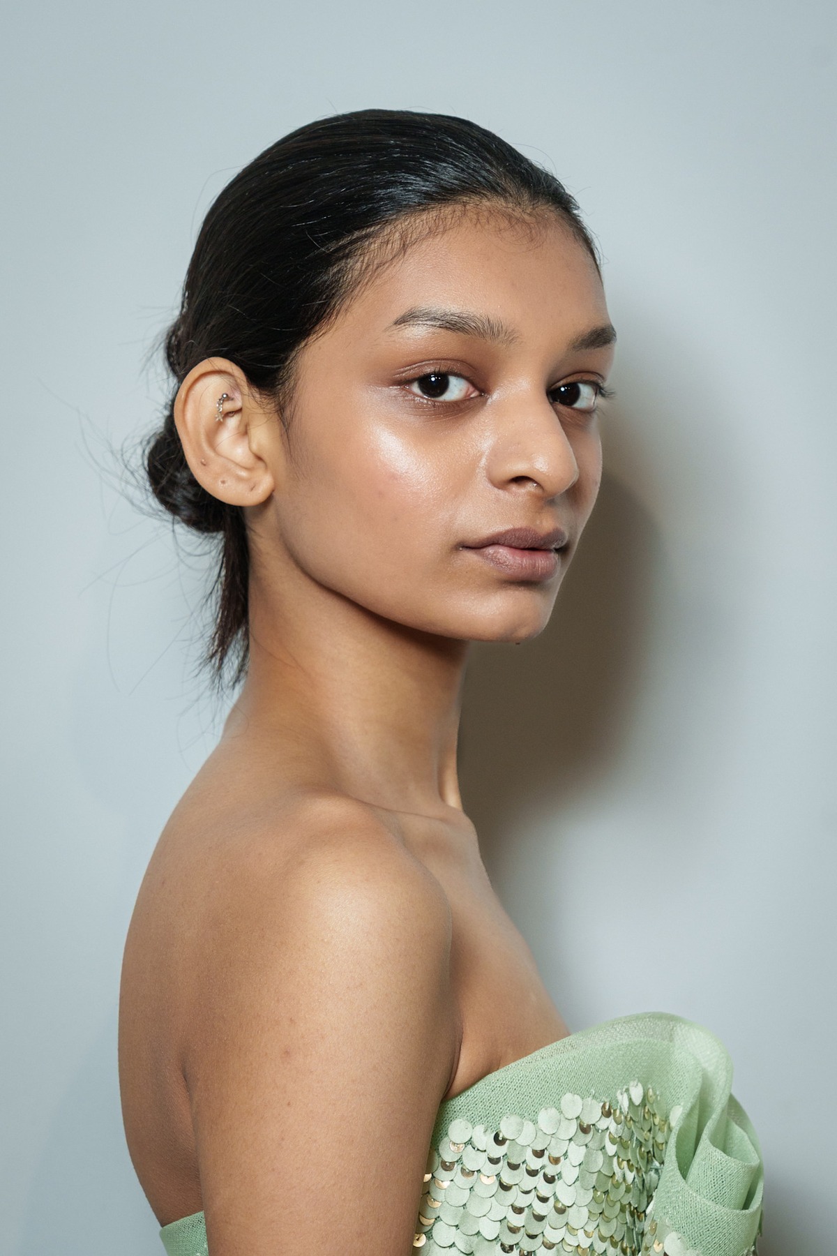 A model showing off a deconstructed chignon wedding hairstyle.