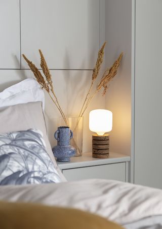 fall bedroom with cork light on side table, dried flowers in vase