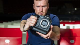 Canon EOS R1 mirrorless camera in the hand, no lens attached