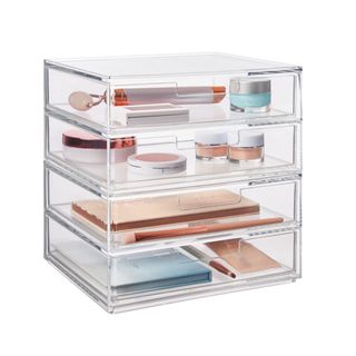 An acrylic desk organizer with makeup in it