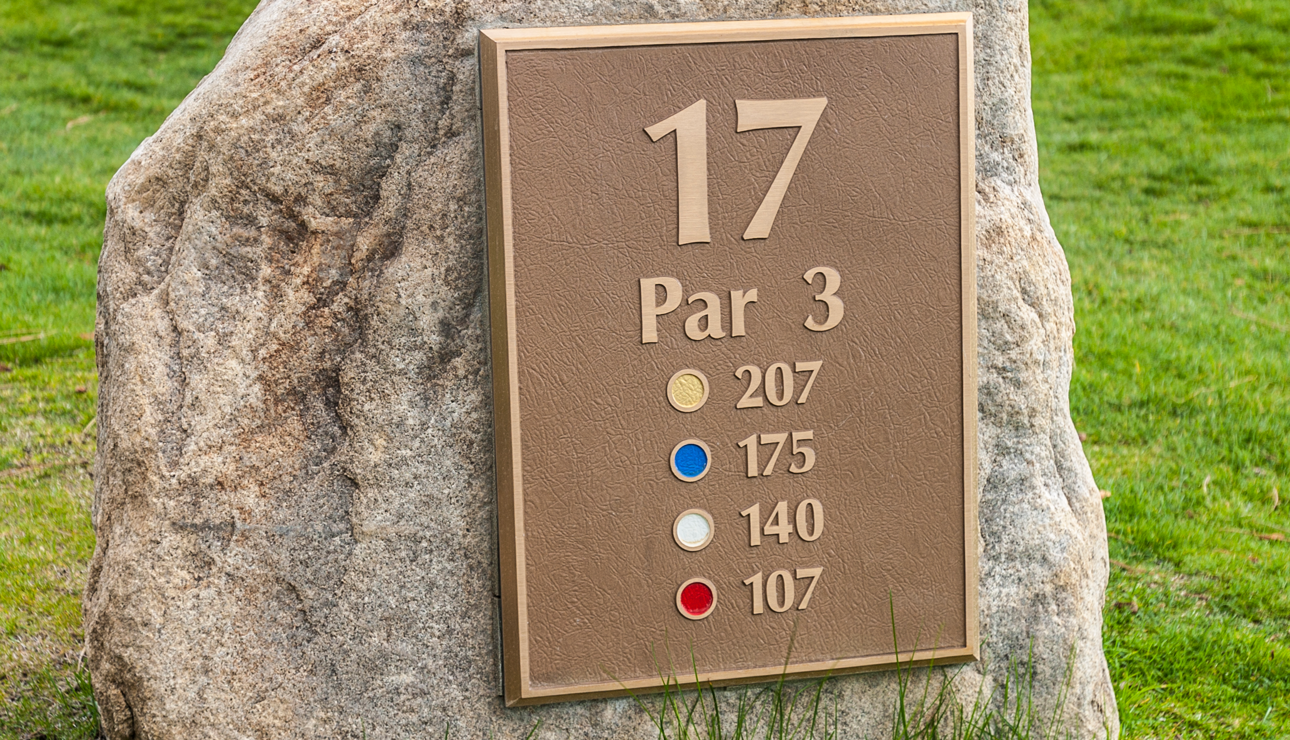 A tee marker with different yardages on it