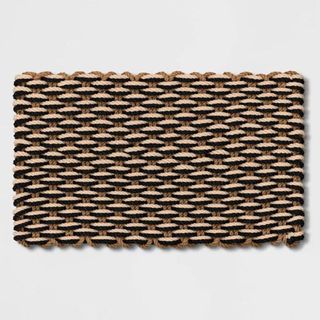 A brown. black, and cream robe braided doormat is one of the best Target fall decor items for outside.
