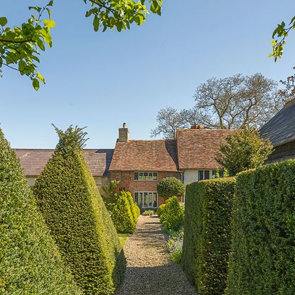 house exterior with brick walls and garden area