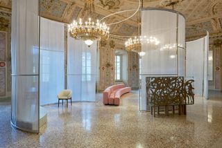 Interior of 18th century palazzo in Como with displays if pink Pierre Paulin sofa and white chair as part of Lake Como Design Festival displays
