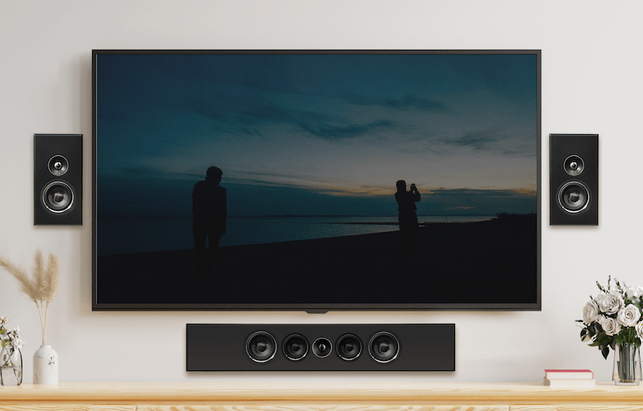 Two PSB PWM Sat speakers on either side of a large TV, with a larger PSB speaker underneath