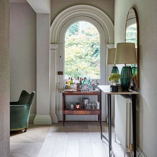 Bar cart under arched window in a period home