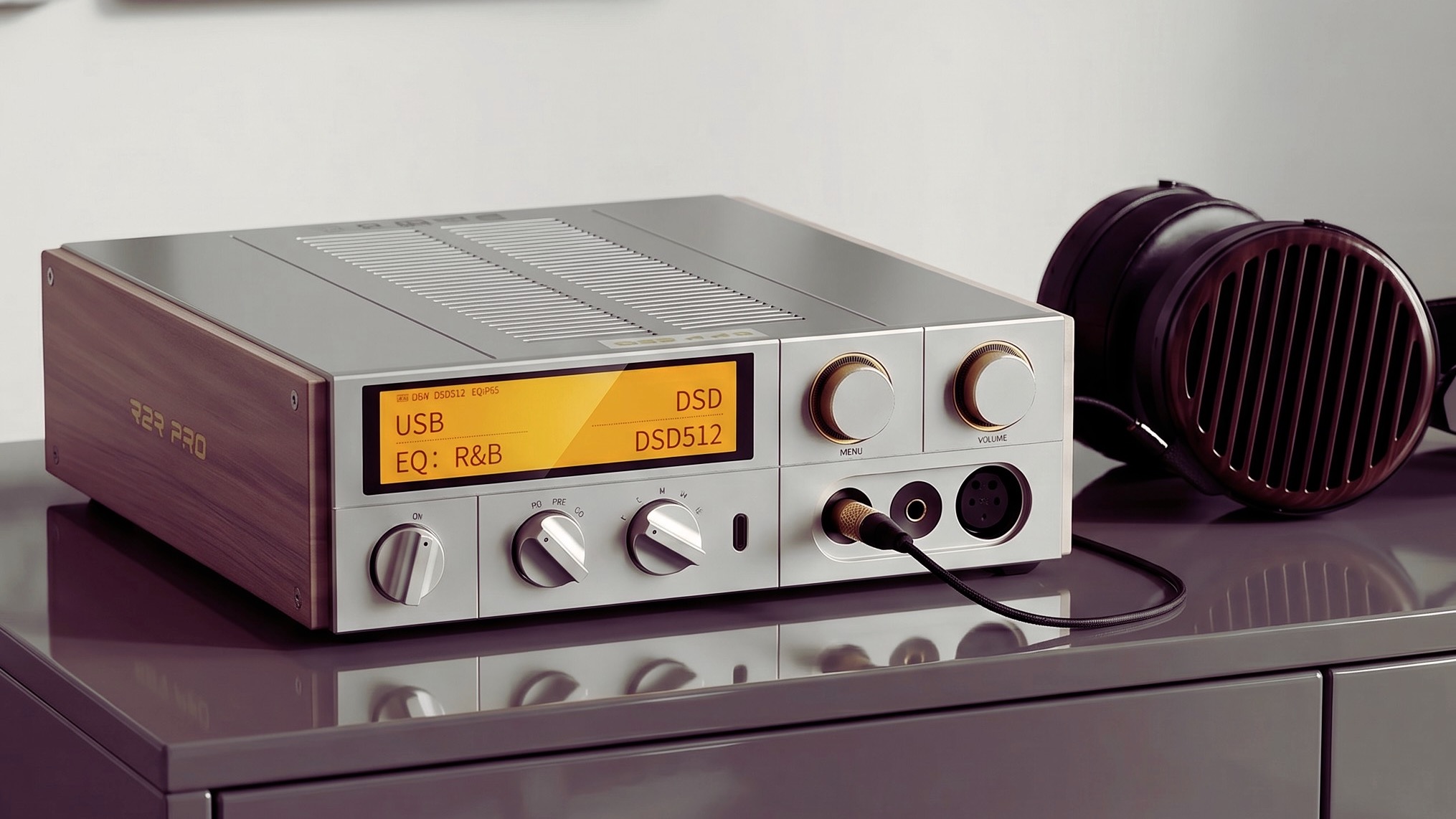 The K17 R2R Pro on a cabinet surface with a pair of over-ear headphones plugged into it.