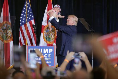 Donald Trump holds aloft a Florida baby