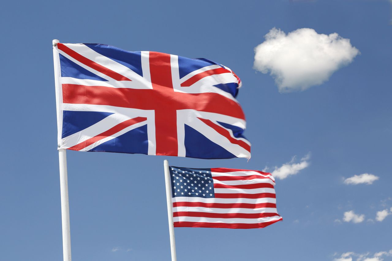 Flags of the UK and USA floating in the sky