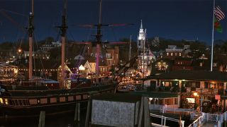 A shot of the city of Newport lit up at night with a sail boat in the foreground in A Newport Christmas.