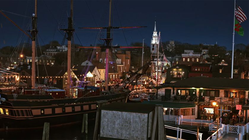 A shot of the city of Newport lit up at night with a sail boat in the foreground in A Newport Christmas.