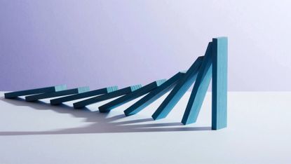 closeup of a row of falling blue wooden dominoes