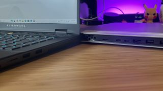 Close up on Alienware M16 R2 side ports and Alienware X16 R2 rear ports on a wooden desk