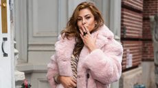 picture of Eva Mendes on street in pink coat blowing a kiss