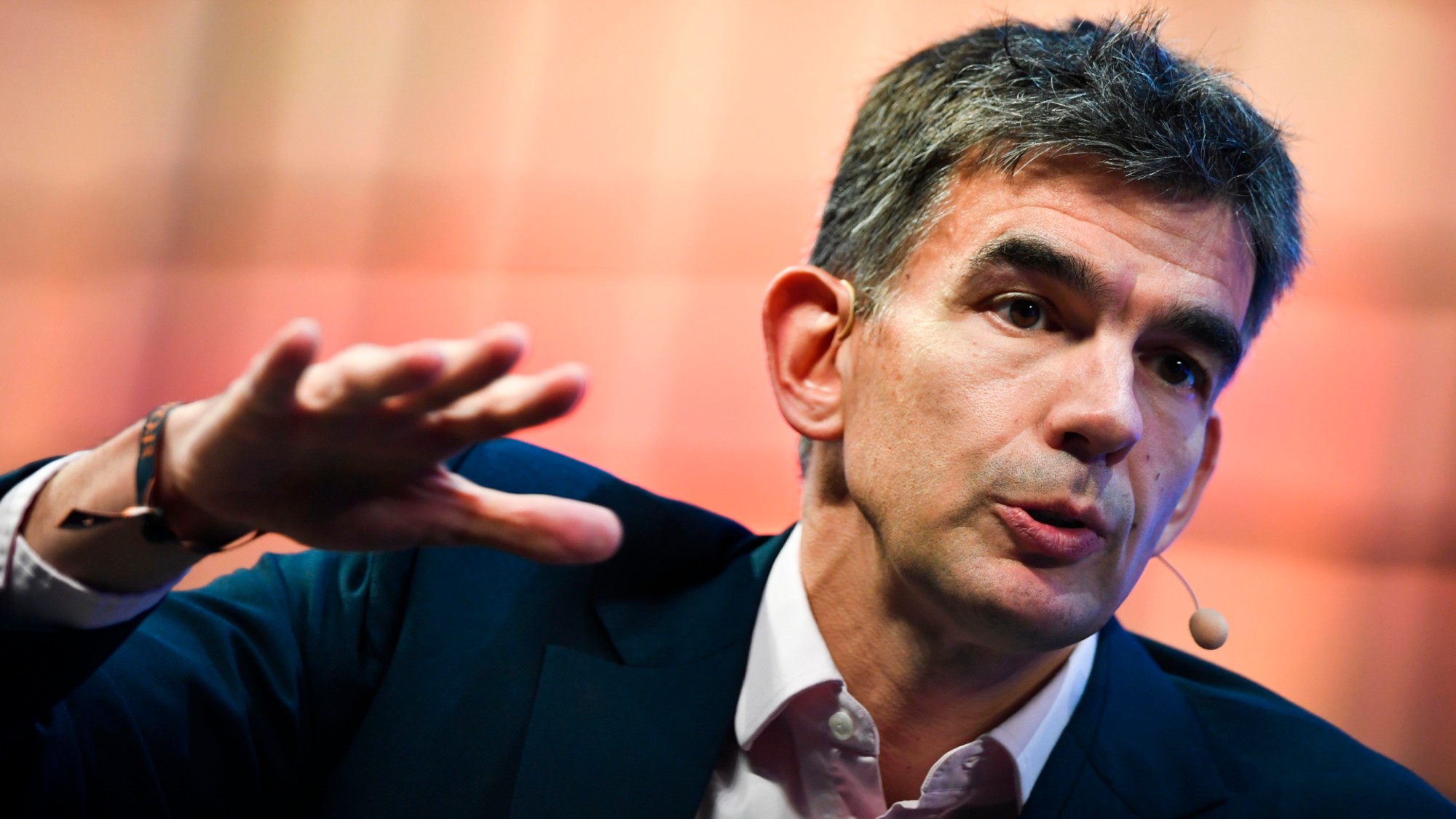 Matt Brittin, pictured in 2017, with a mic and holding hand out