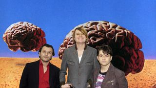 The Manic Street Preachers in front of the artwork for Rush's Hemispheres