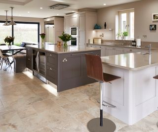 large kitchen with central island housing appliances and storage below, with seating area built off to one side of island in front of large sliding patio doors