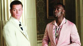 Matt Damon and Don Cheadle stand near each other dressed in suits in Ocean's Twelve.