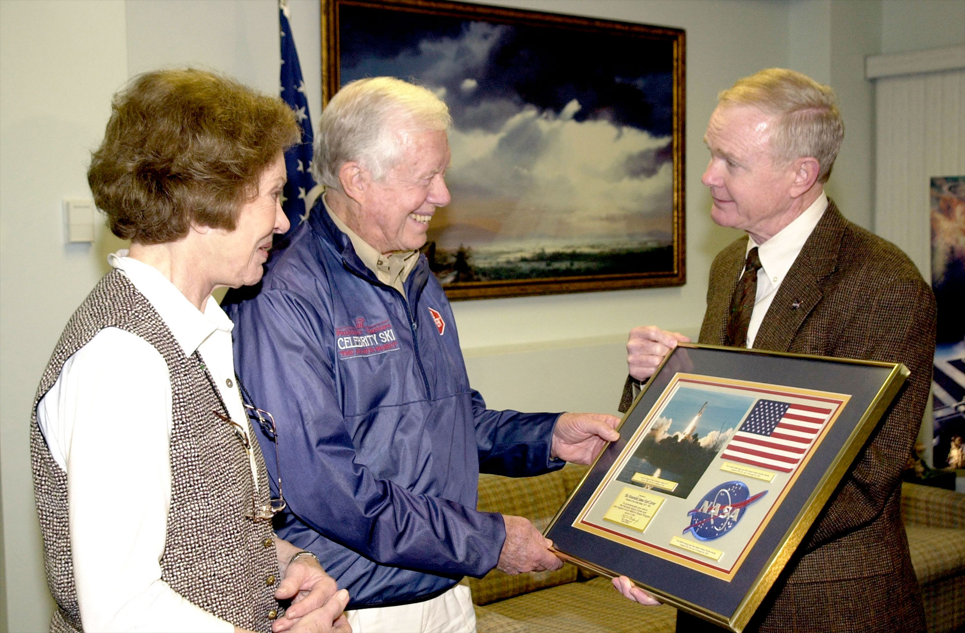 the president of the united states and first lady are presented with a framed american flag by the director of nasa's kennedy space center