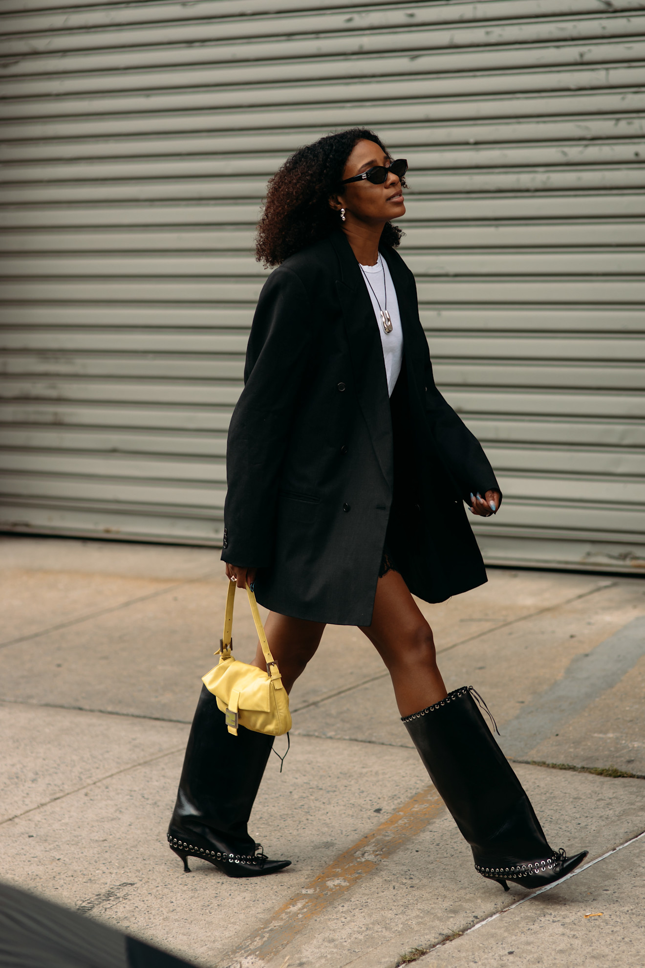 naomi elizee wearing black blazer, white shirt, and boots