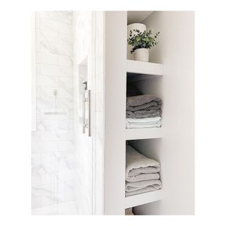 Discreet towel nook in white bathroom