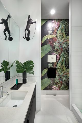 white bathroom with exotic leaf wallpaper and monkey light