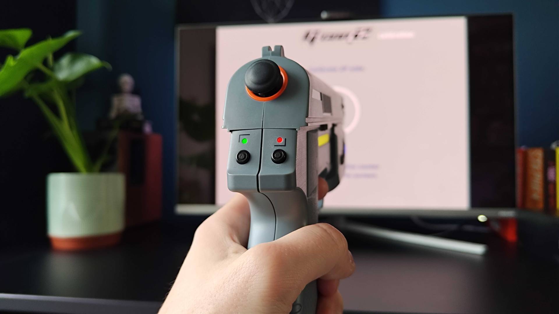 Hand holding Intec Time Breaker Lightgun left calibration green and right light red.