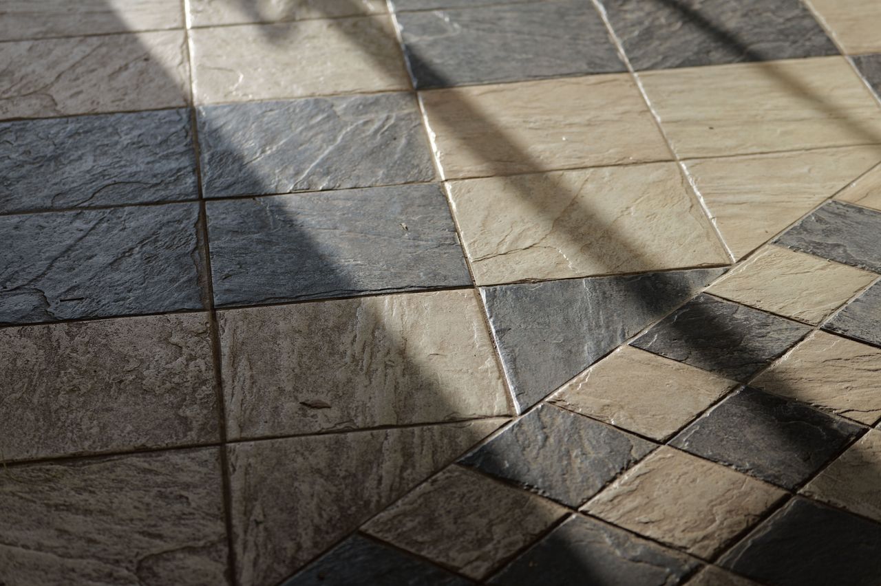 Sun setting across a black and white tiled floor