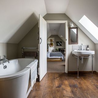attic bathroom with wooden floor and bathtub