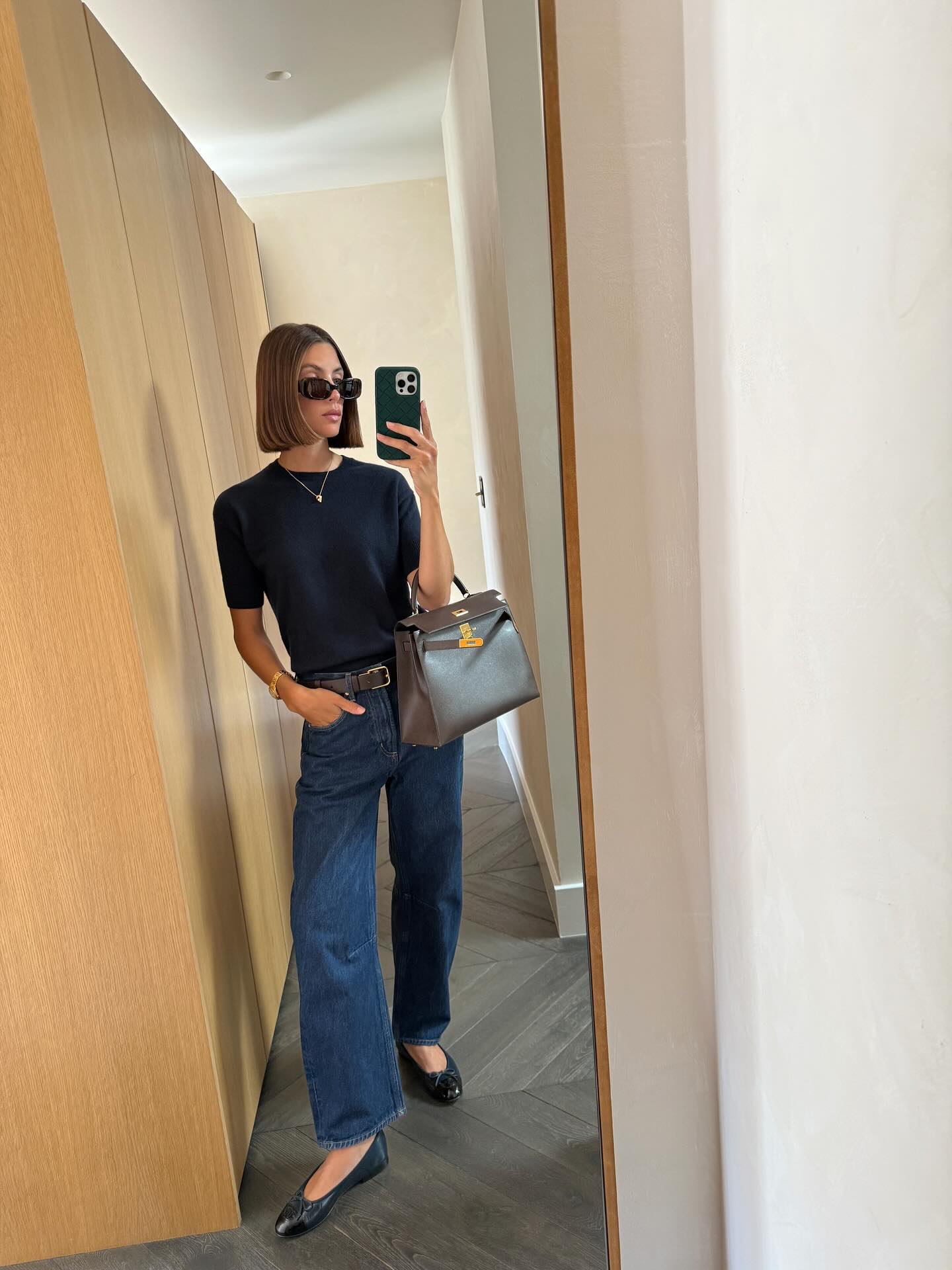 @jaimeridge wears blue bootcut jeans with ballet flats.