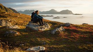 Woman sitting looking out at a view while hiking