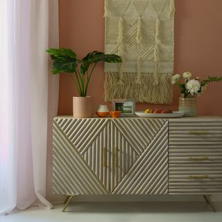 Coral pink dining room with textured statement sideboard