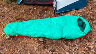 Kelty Cosmic Down 20 sleeping bag on forest floor